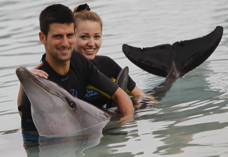Jelena Ristic e NovakDjokovic accarezzano un delfino nella laguna di Dubai (Ap)